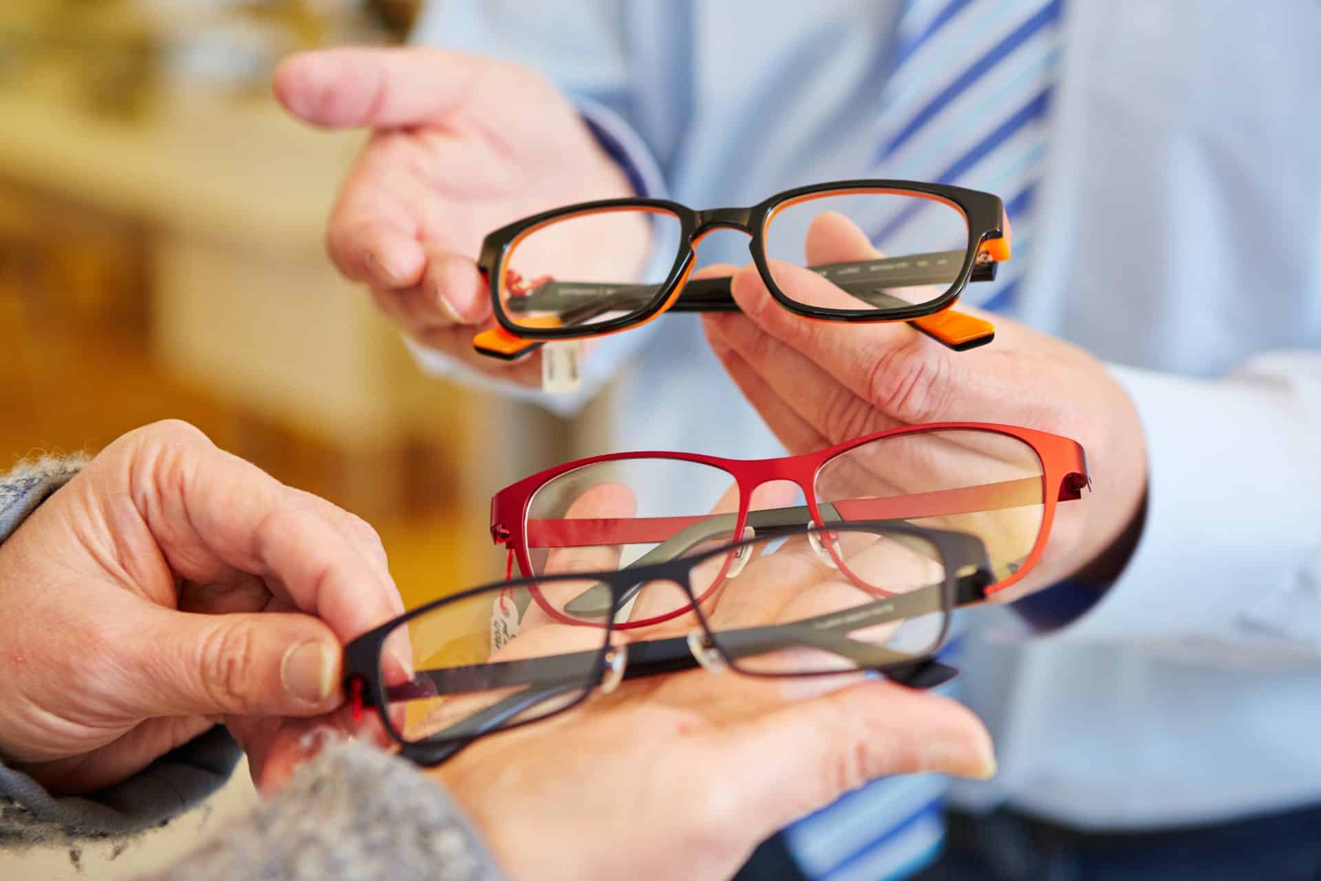 Optician offering a customer a choice of different glasses